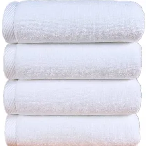 Stack of premium absorbent white hotel cotton towels for professional bath use