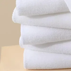 Close-up of stacked white microfiber towels showing soft texture and thickness.