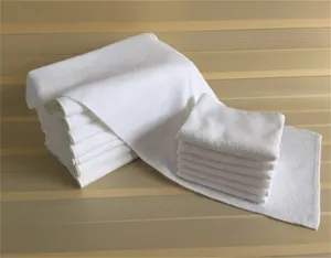 Detalle de toallas blancas de punto por urdimbre apiladas para uso en hoteles y spas.
