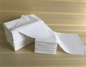 Primer plano de una pila de toallas blancas absorbentes de punto para hoteles y spas