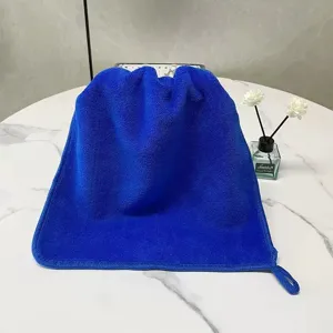 Macro detail of thick blue coral fleece absorbent hand towel with a hanging loop