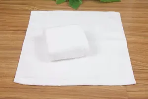 Detail view of soft white cotton square towel showing weave texture and folded shape.