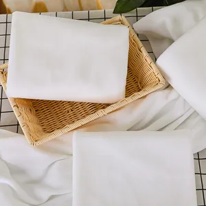 Juego de toallas de baño blancas desechables suaves y absorbentes en una cesta de mimbre