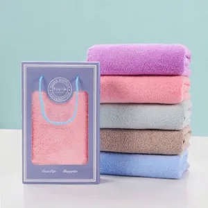 Weiche saugfähige Handtücher in verschiedenen Farben mit lilafarbener Geschenkschachtel.