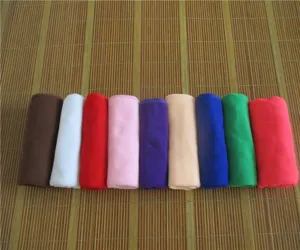 Soft absorbent microfiber towels in multiple colors rolled on a natural bamboo mat