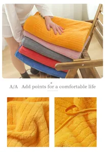 Detail view of soft striped coral fleece bath towel with hanging loop and plush texture