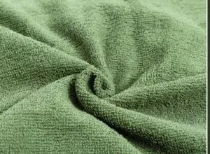Macro dettaglio ravvicinato della morbida trama in tessuto di spugna verde e densa