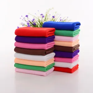 Close-up of stacked colorful thin microfiber car wash towels showing texture and variety