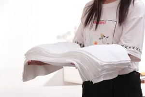 Detailed view showing the thickness of a large stack of white absorbent disposable towels