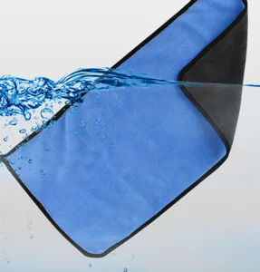 Macro shot of a thick blue and black coral velvet car wash towel with water splash