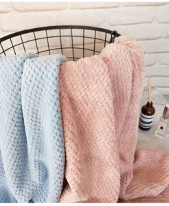 Morbidi asciugamani da bagno a griglia rosa e blu esposti in un moderno cesto decorativo