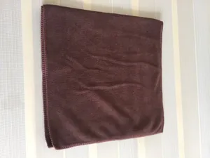 Close-up of a folded chocolate brown microfiber towel with stitched edges