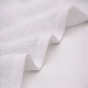 Detailed macro view showing the thick absorbent texture and edge of a white cotton towel