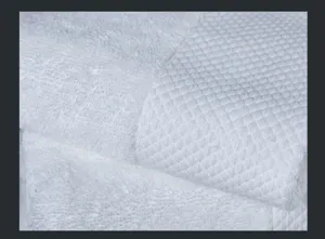 Makrodetail der Textur eines flauschigen weißen Baumwoll-Badetuchs mit Rautenwebuster