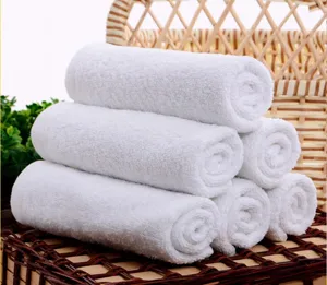 Detailed macro view of soft white cotton towels stacked in a wicker basket