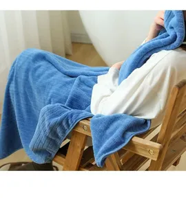 Detailed view of the soft blue coral fleece bath towel with vertical stripes on a person.