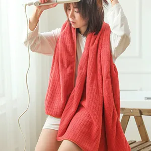 Asian woman using a red striped coral fleece bath towel in a bright bathroom setting