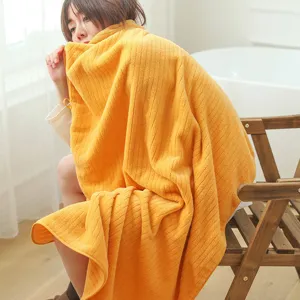 Macro view of soft orange striped coral fleece bath towel in a cozy bathroom setting