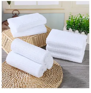 Detail view of white striped cotton towels neatly arranged on a natural woven mat