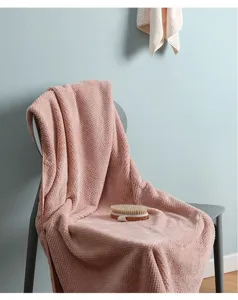 Primer plano de una toalla de baño rosa con diseño de piña sobre una silla gris