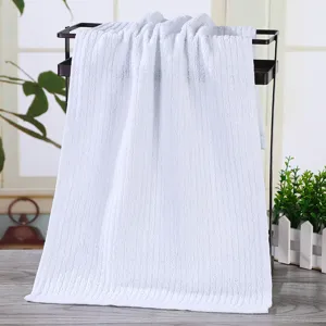 Absorbent white cotton hotel bath towel featuring a vertical ribbed striped texture