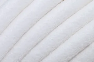 Close-up van de witte pluche handdoek stof tekstur met mooie zachte gevouwen lijnen.