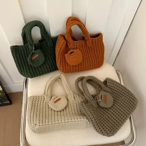 Detailed display of four handmade crochet tote bags in green, orange, beige, and taupe.