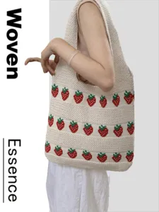 Stylish cream knitted tote bag with strawberry pattern shown carried by an Asian model