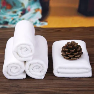 Set of soft white absorbent hotel towels and face cloths for bathroom and spa use