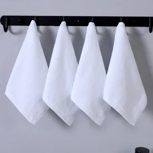 Detailweergave van vier witte katoenen washandjes die aan een zwart haakrek hangen