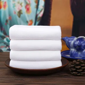 Premium set of four soft white absorbent cotton towels for hotel and home bath use