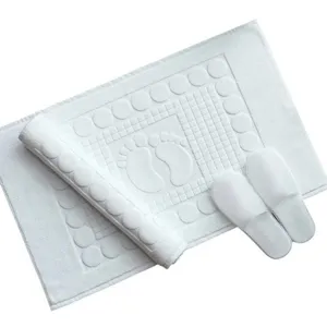 White pure cotton hotel bath mat with anti-slip foot pattern and matching slippers