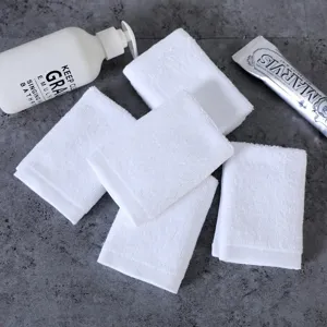Set van 5 puur witte katoenen vierkante handdoeken voor bad en reiniging op grijs