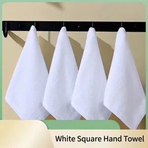 Zachte witte katoenen vierkante washandjes hangen aan een haakrek voor badkamer