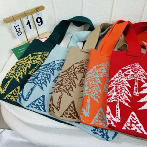 Vista detallada de varios bolsos de punto coloridos con estampados de árboles de Navidad