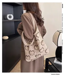Elegante borsa tote in maglia con motivo a cuore indossata da una modella in blazer
