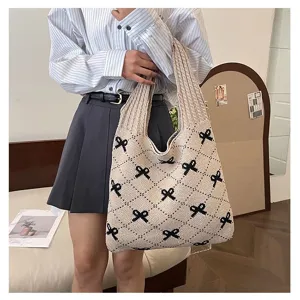 Close-up detail of knitted large capacity tote bag with black bow jacquard patterns