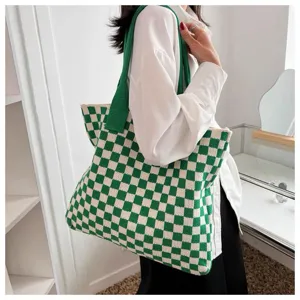 Detailed view of a large green and white checkered knitted tote bag held by a female model.