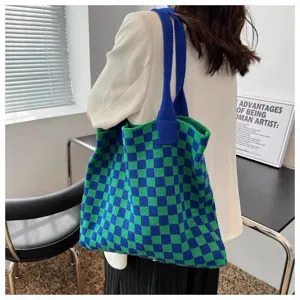 Detail of green and blue checkered knitted tote bag carried by a model