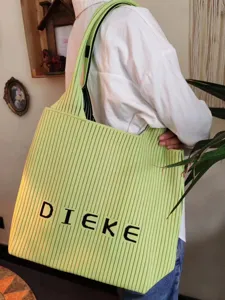 Detailed view of a lime green pleated knitted tote bag worn over the model's shoulder