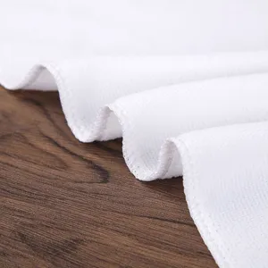 Primer plano detallado de una toalla blanca de hotel que muestra textura suave y bordes cosidos