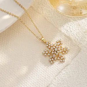 Macro detail of a gold-plated snowflake pendant necklace encrusted with cubic zirconia