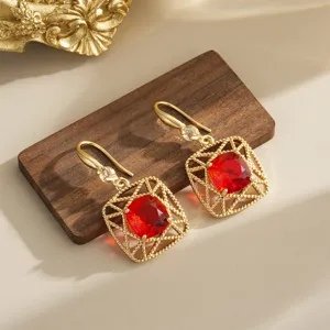 Close-up of vintage red crystal earrings with gold lattice frame details