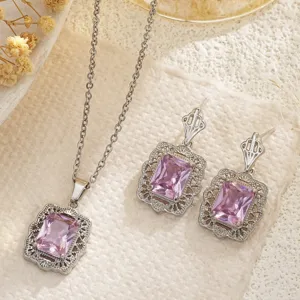 Primer plano de un conjunto de joyas con circonitas rosas y marcos de filigrana de plata.