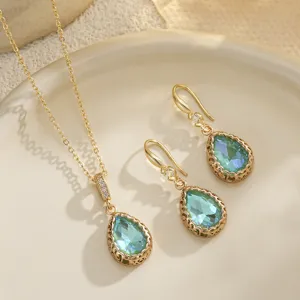 Close-up of elegant bridal jewelry set with blue teardrop pendants and gold filigree