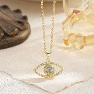 Detail macro view of the rotatable evil eye pendant with blue crystals and gold chain