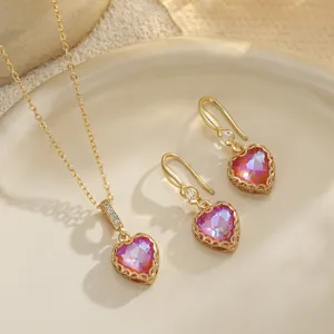 Nahaufnahme von Vintage Herz-Schmuckset mit rosa Farbverlauf Zirkonia und goldenen Spitzenkanten.