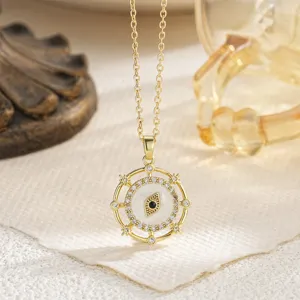 Close-up of rotating gold-plated evil eye necklace pendant with crystal embellishments.