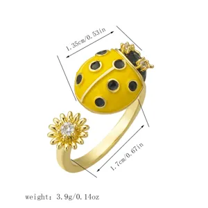 Detail view of a gold ladybug and flower rotating open ring with size and weight info
