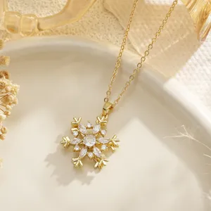 Close-up detail of a delicate gold-toned snowflake pendant set with sparkling zircons